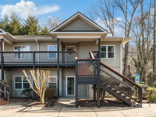 a view of a house with large windows and a small yard