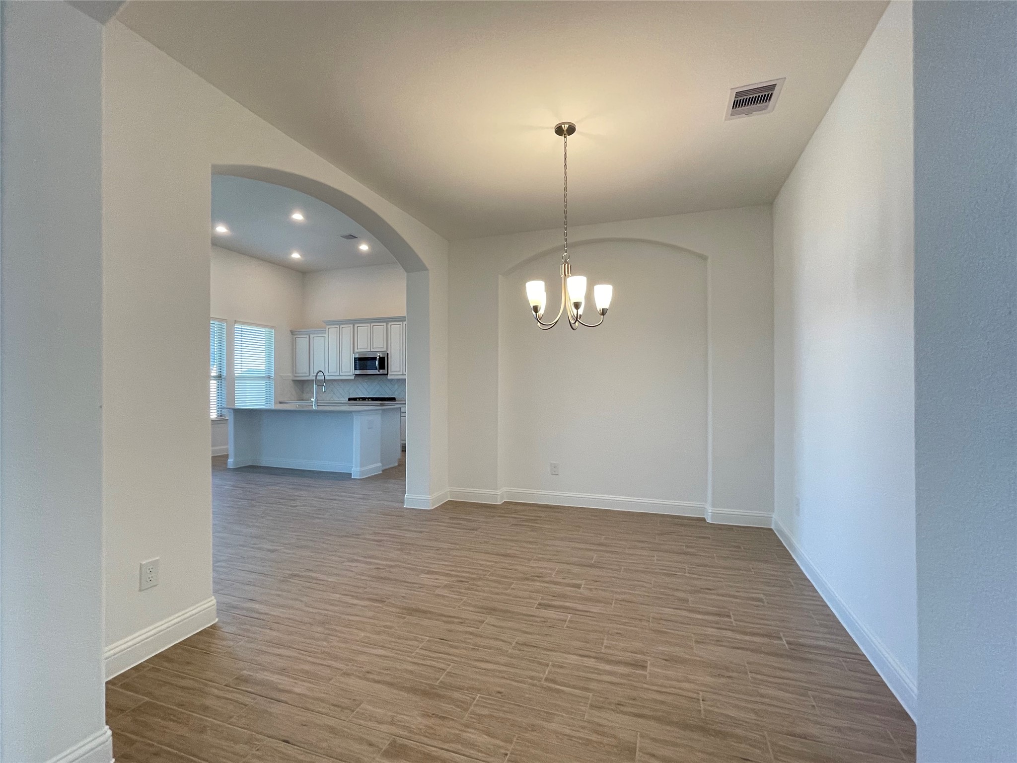 29806 Cherry Vine Road Katy, TX 77494 - Photo 4 of 30 an empty room with wooden floor kitchen view and a window