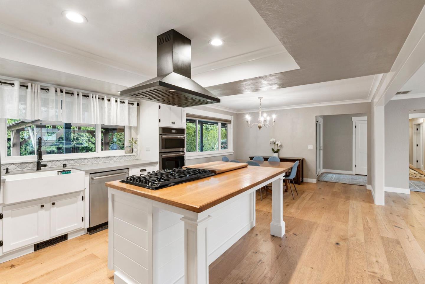 105 Rays Circle Hollister, CA 95023 - Photo 14 of 37 a kitchen with stainless steel appliances a stove a sink dishwasher and a dining table with wooden floor