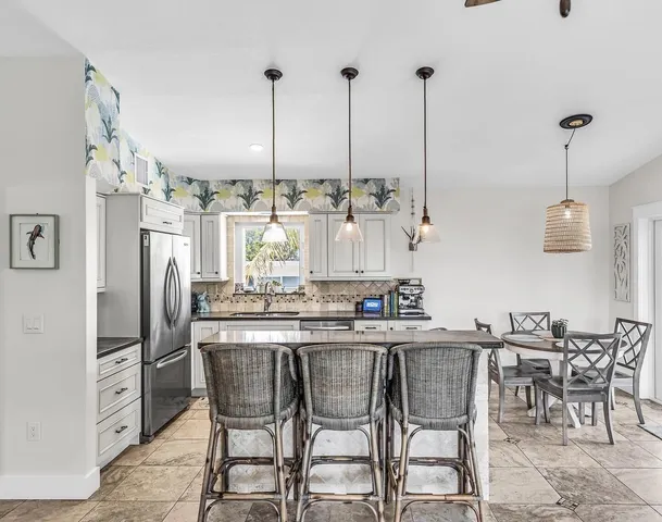 a kitchen with stainless steel appliances kitchen island granite countertop a table and chairs