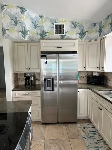a kitchen with stainless steel appliances granite countertop a refrigerator and a stove