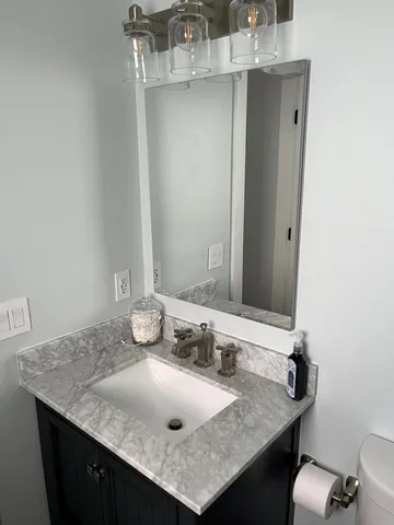 a bathroom with a granite countertop sink and a mirror
