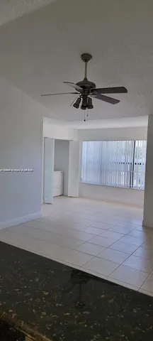 a view of empty room with wooden floor and window