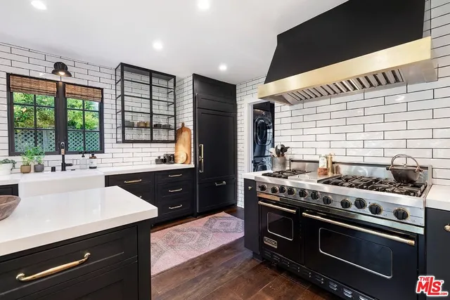 a kitchen with a counter space a sink appliances and cabinets