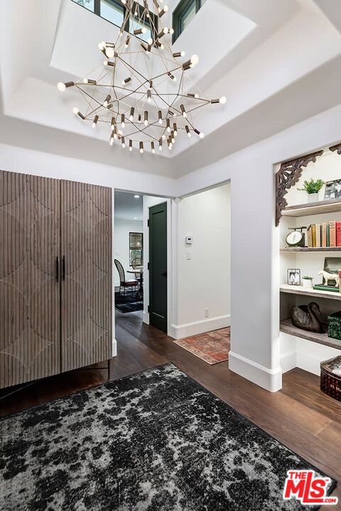 4416 Arcola Avenue Toluca Lake, CA 91602 - Photo 29 of 46 a view of a hallway with wooden floor and a chandelier