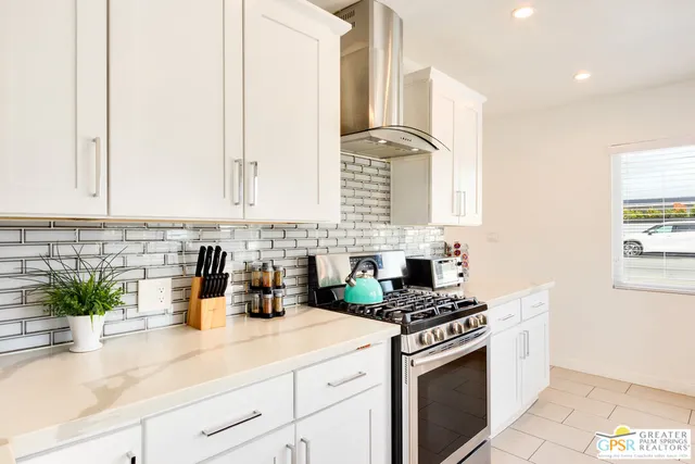 a kitchen with stainless steel appliances white cabinets and a stove top oven
