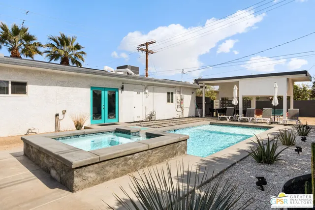 a view of a house with backyard and sitting area