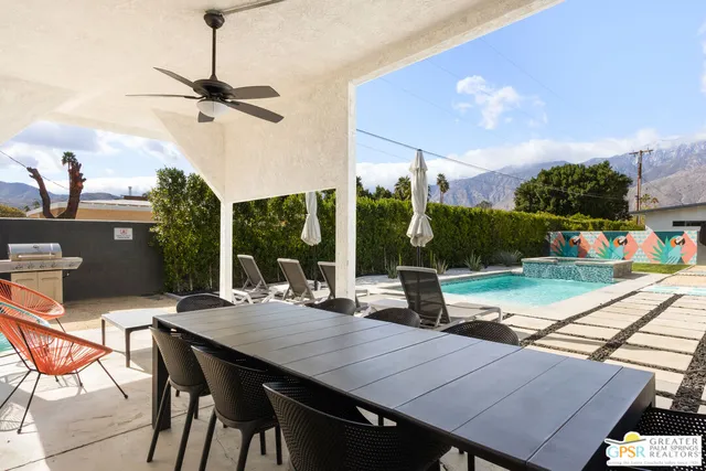 a view of a patio with a table chairs and a floor to ceiling window