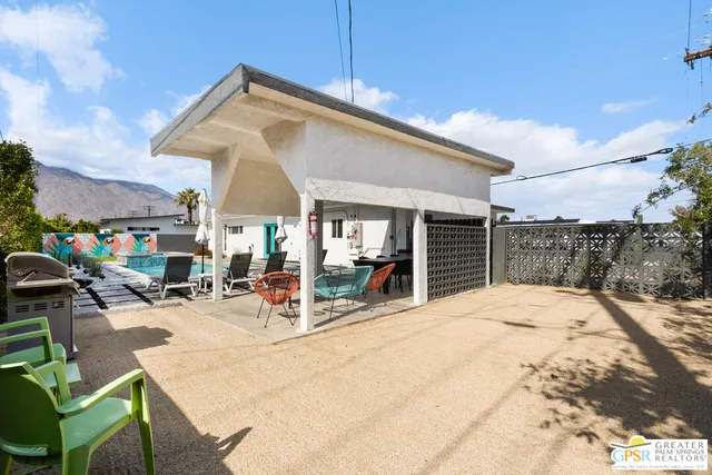 a view of a patio with a table and chairs under an umbrella