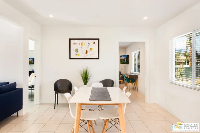 a living room with furniture and a painting on the wall