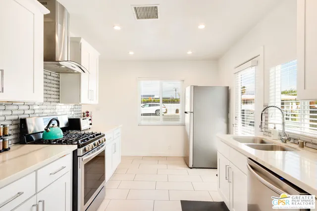 a kitchen with a sink a refrigerator and cabinets