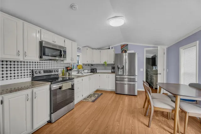 a kitchen with granite countertop a refrigerator stove top oven and sink