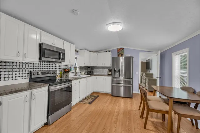 a kitchen with a sink a counter top space stainless steel appliances and cabinets
