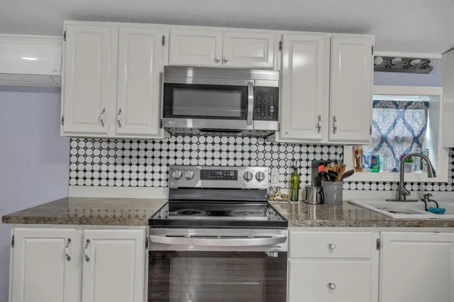 a stove top oven sitting inside of a kitchen