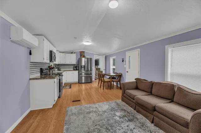 a living room with furniture and kitchen view