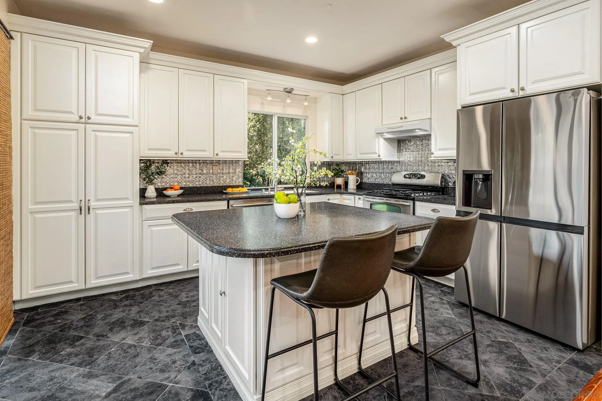 5462 Senegal Street Oceanside, CA 92057 - Photo 12 of 47 a kitchen with stainless steel appliances granite countertop a stove a refrigerator a sink a stove with white cabinets and wooden floor
