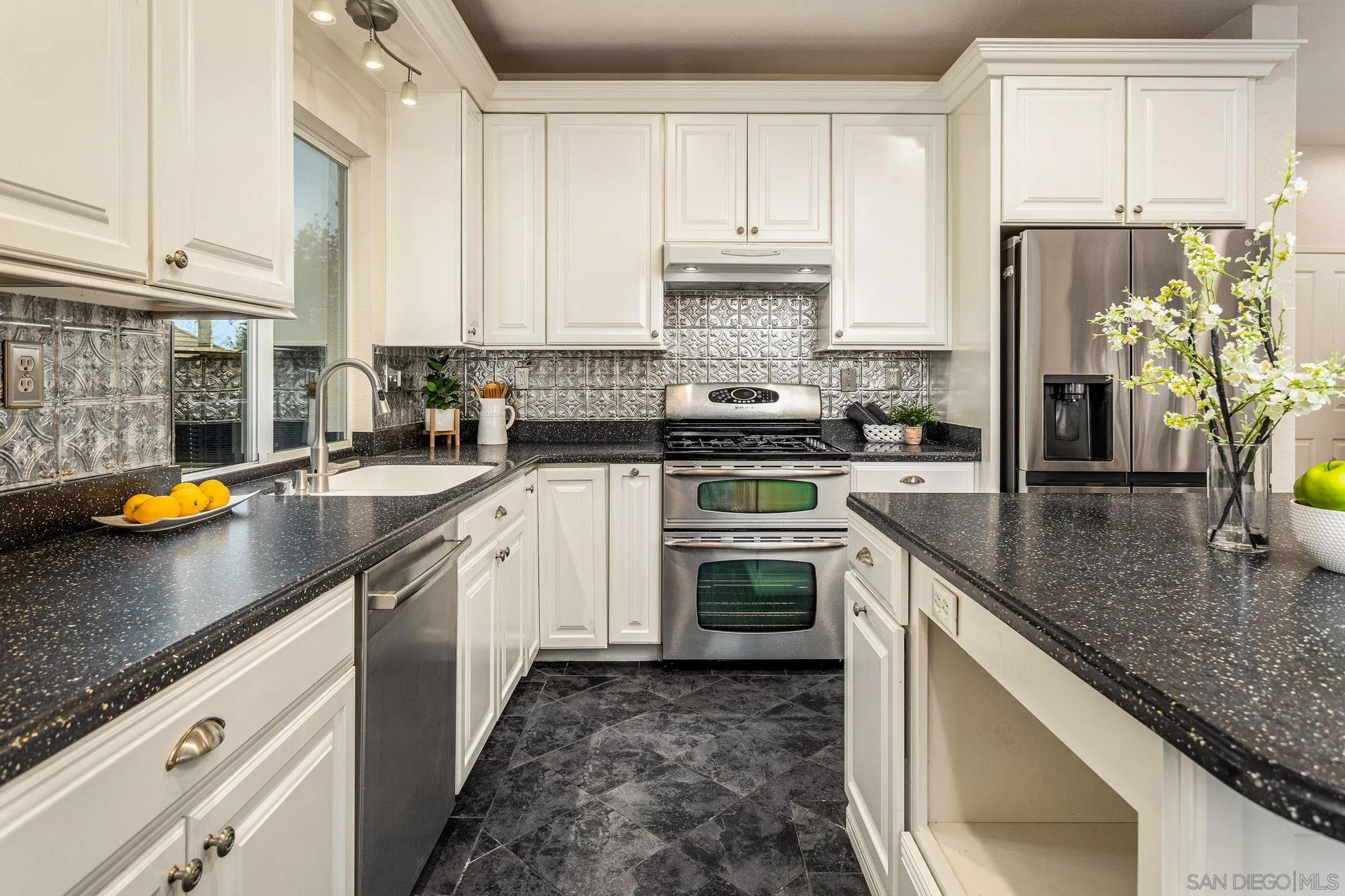 5462 Senegal Street Oceanside, CA 92057 - Photo 13 of 47 a kitchen with stainless steel appliances granite countertop a sink a stove and a white cabinets