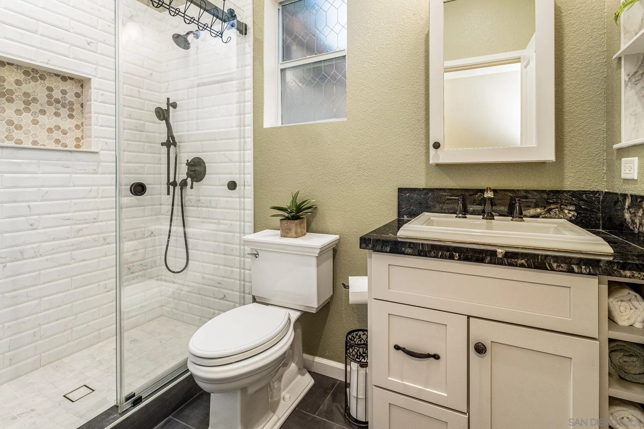 5462 Senegal Street Oceanside, CA 92057 - Photo 15 of 47 a bathroom with a granite countertop toilet sink and mirror