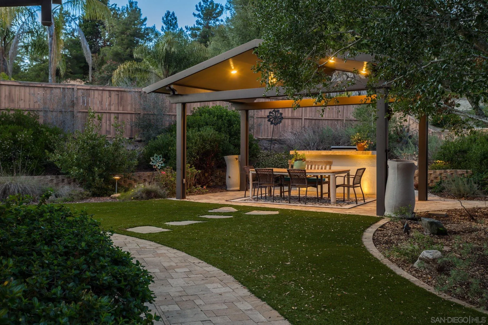 5462 Senegal Street Oceanside, CA 92057 - Photo 36 of 47 a patio with table and chairs and potted plants with wooden fence