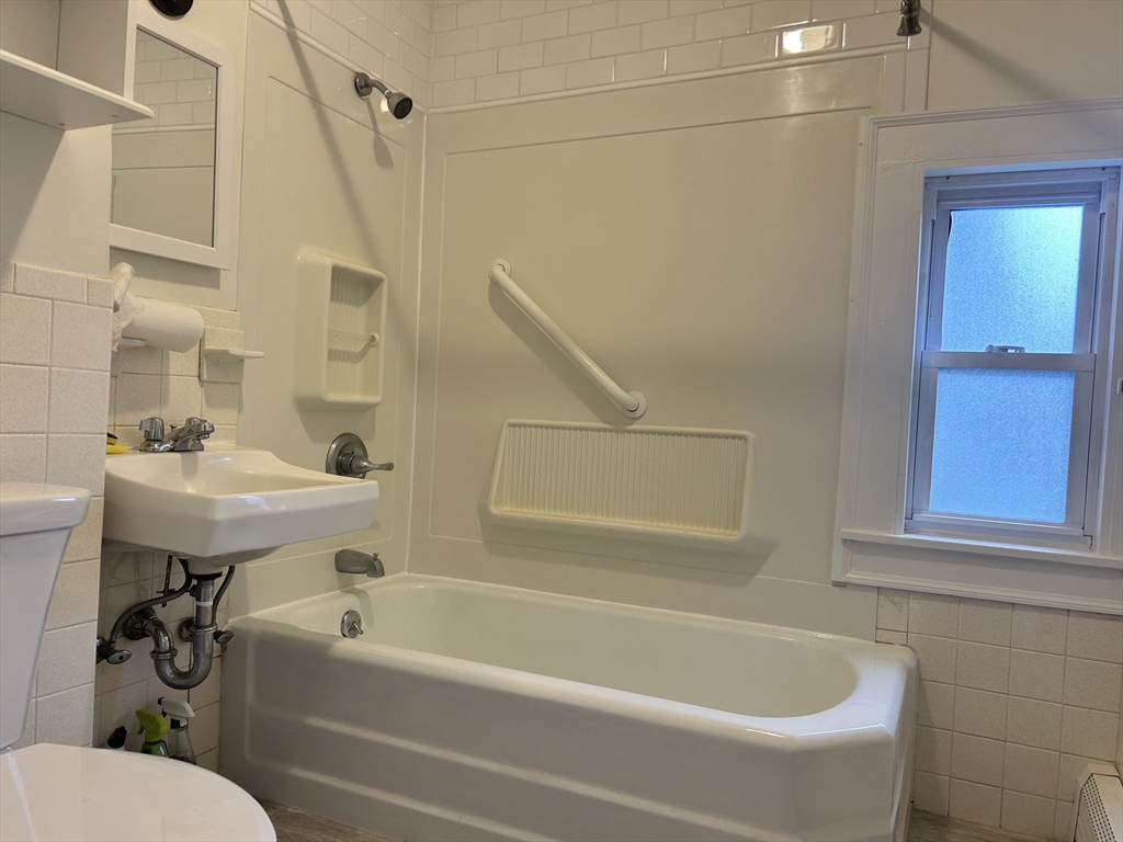 17 Lincoln Street, Unit 2 Greenfield, MA 01301 - Photo 20 of 26 a white bath tub sitting next to a white sink and a mirror