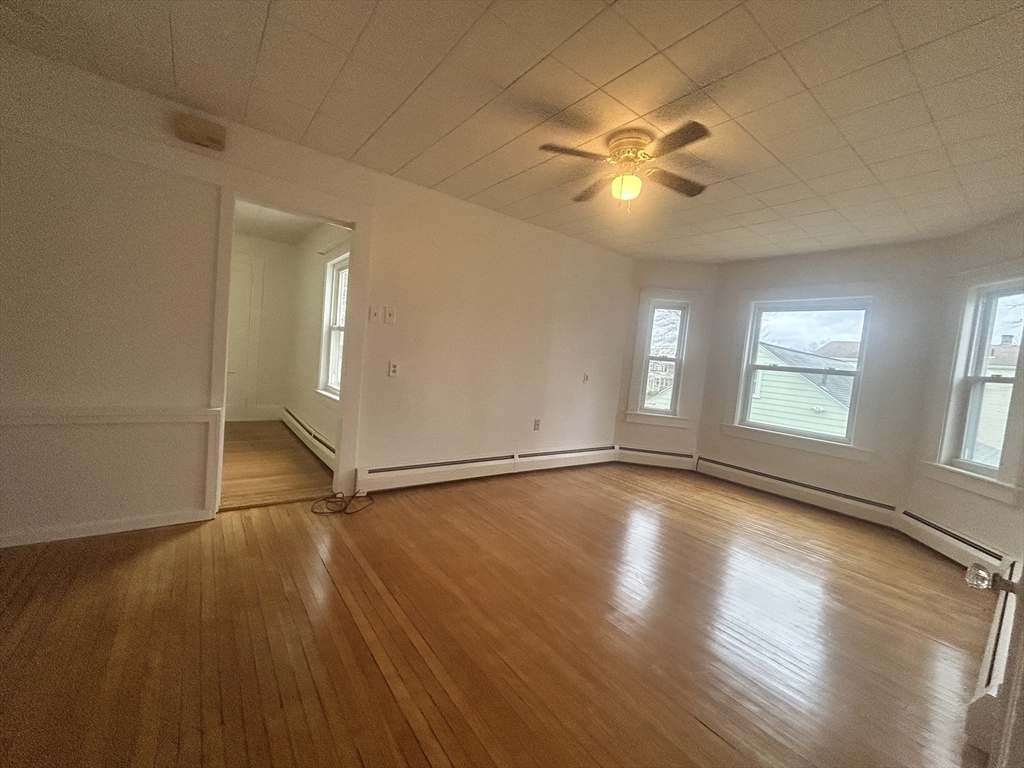 17 Lincoln Street, Unit 2 Greenfield, MA 01301 - Photo 8 of 26 an empty room with wooden floor fan and windows