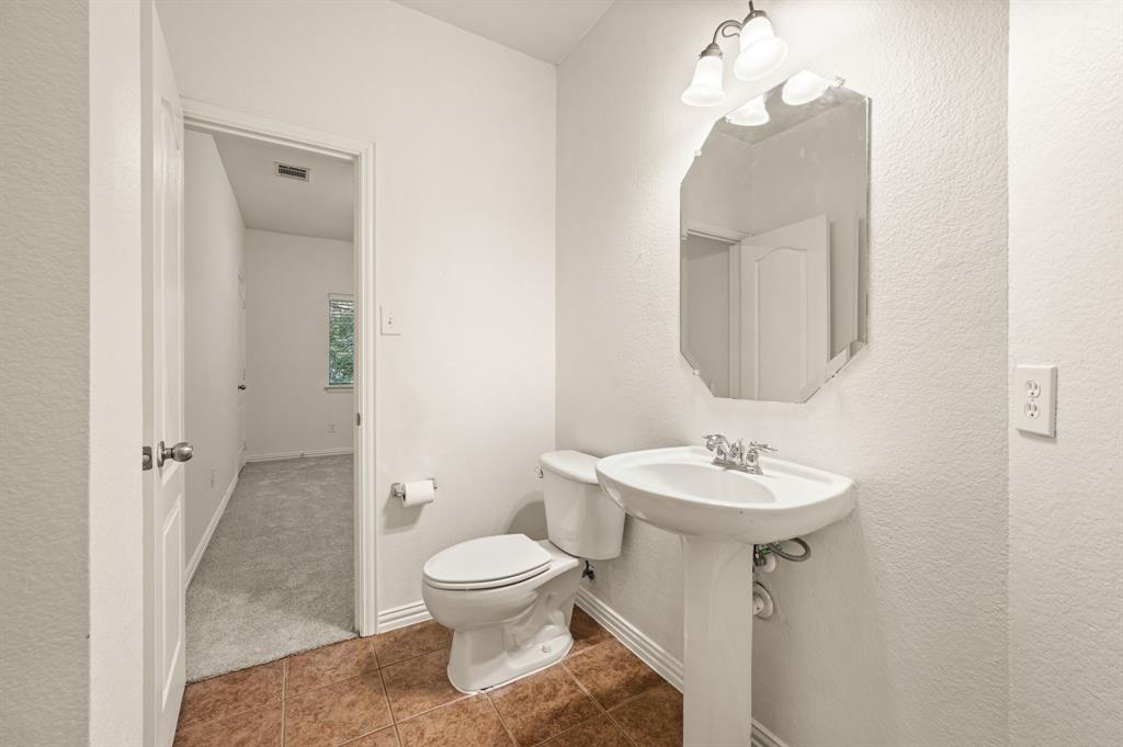 808 Briar Ridge Drive Keller, TX 76248 - Photo 23 of 40 Pedestal sink with chrome faucet, octagonal mirror, and a two-light vanity fixture