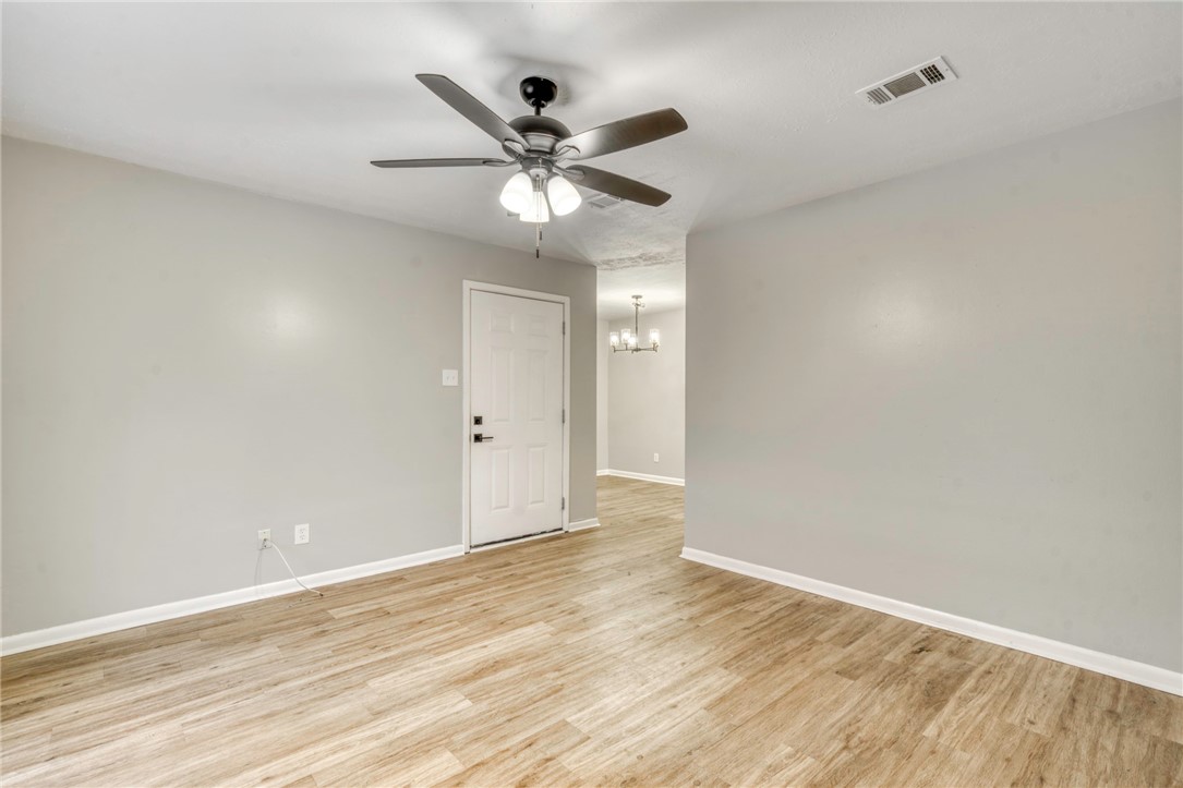 3911 Olive Street, Unit A Bryan, TX 77801 - Photo 3 of 12 a view of an empty room with wooden floor and a ceiling fan