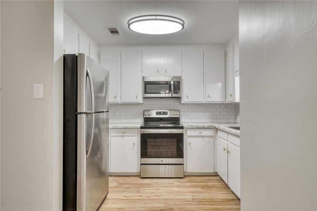 3911 Olive Street, Unit A Bryan, TX 77801 - Photo 6 of 12 a kitchen with a stove and a refrigerator