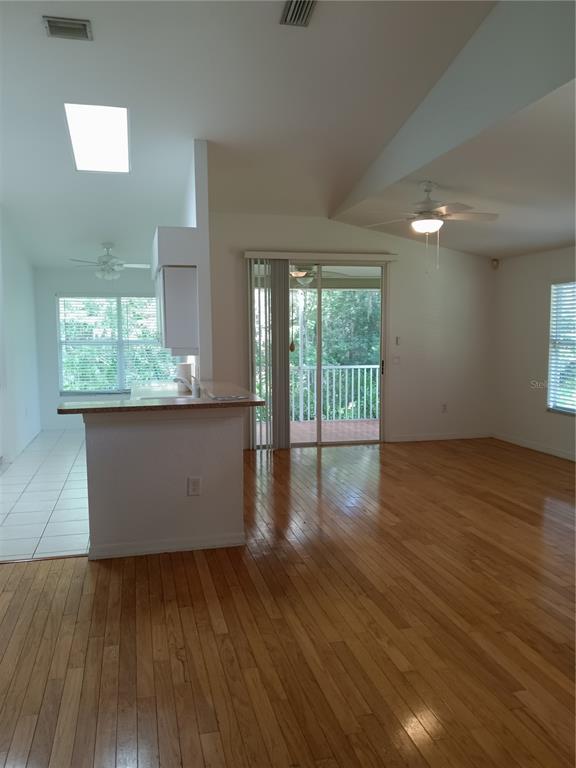 1605 Send Way Lutz, FL 33549 - Photo 6 of 24 an empty room with wooden floor and windows