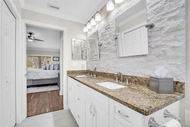 a en suite bathroom with a granite countertop sink and a mirror