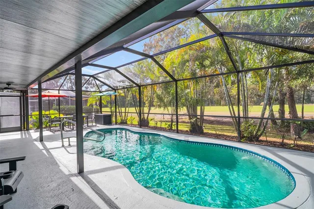 a swimming pool with outdoor seating and garden