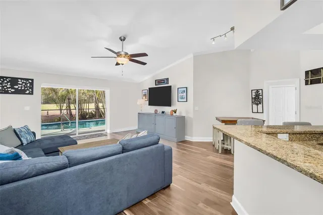 a living room with furniture kitchen view and a flat screen tv