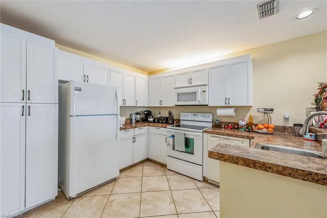 a kitchen with granite countertop cabinets and white appliances