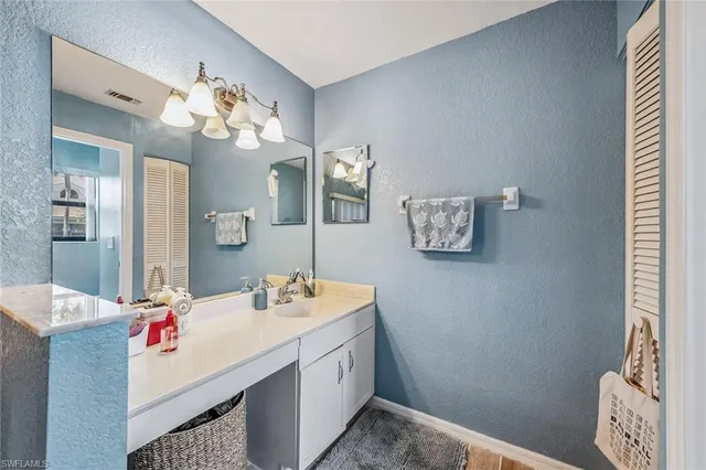 a bathroom with a sink mirror and vanity