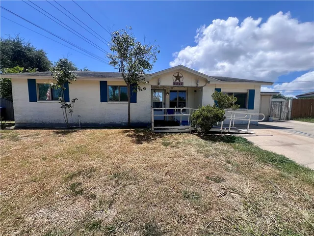 a view of a house with backyard and a tree