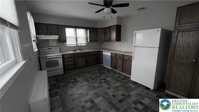 a kitchen with stainless steel appliances granite countertop a refrigerator a stove a sink and a microwave