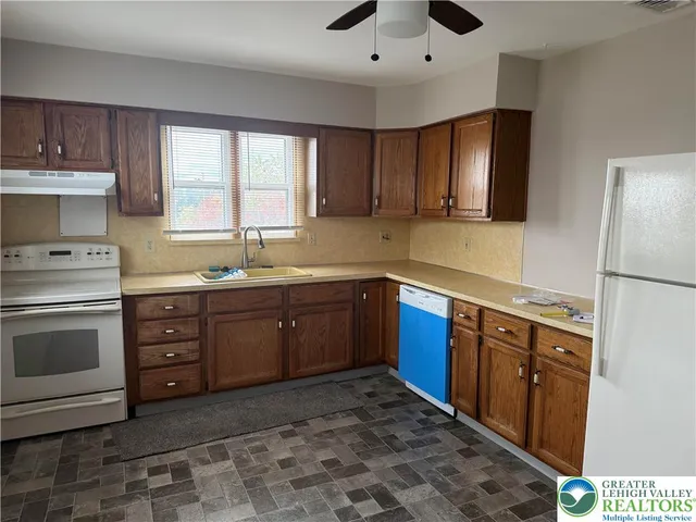 a kitchen with stainless steel appliances kitchen island granite countertop a sink stove and cabinets