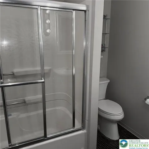 a bathroom with a toilet and a shower