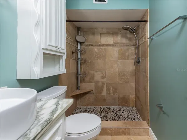 a bathroom with a sink a toilet and shower