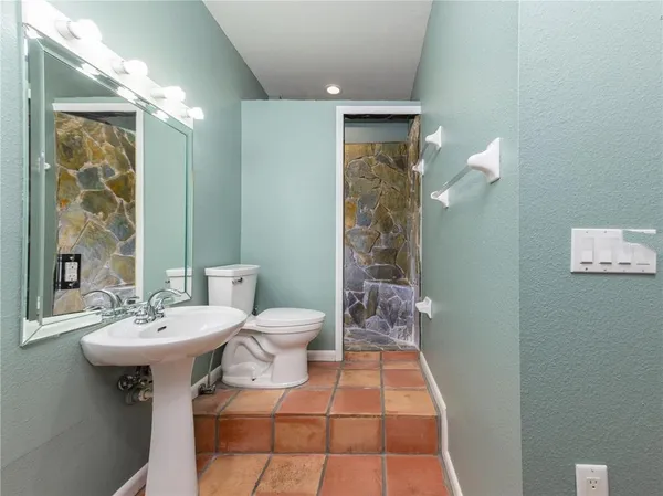 a bathroom with a sink a toilet and shower
