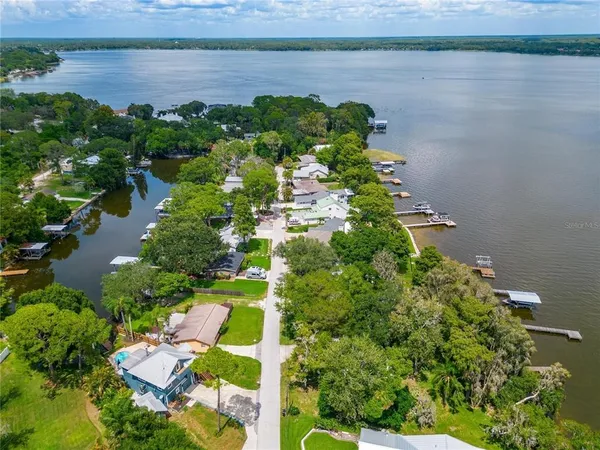 an aerial view of a house with a yard and lake view