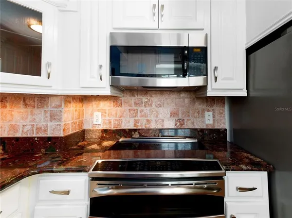 a kitchen with stainless steel appliances granite countertop a stove and a microwave