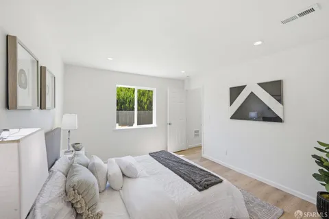 a bedroom with a bed and a potted plant