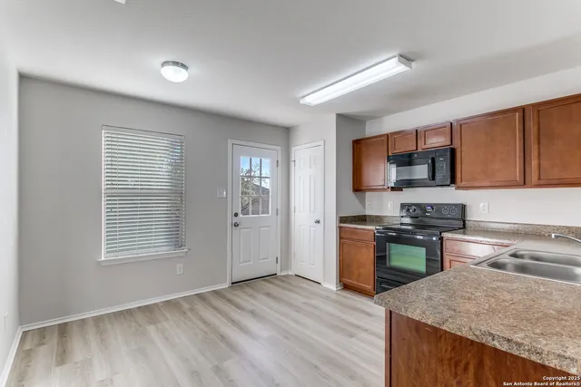 a kitchen with stove top oven and refrigerator