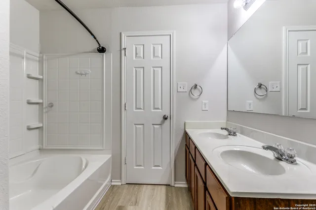 a bathroom with a bathtub shower sink and a mirror