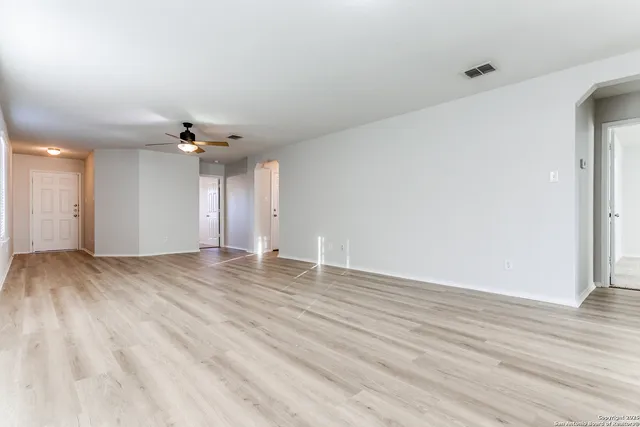 a view of an empty room with wooden floor