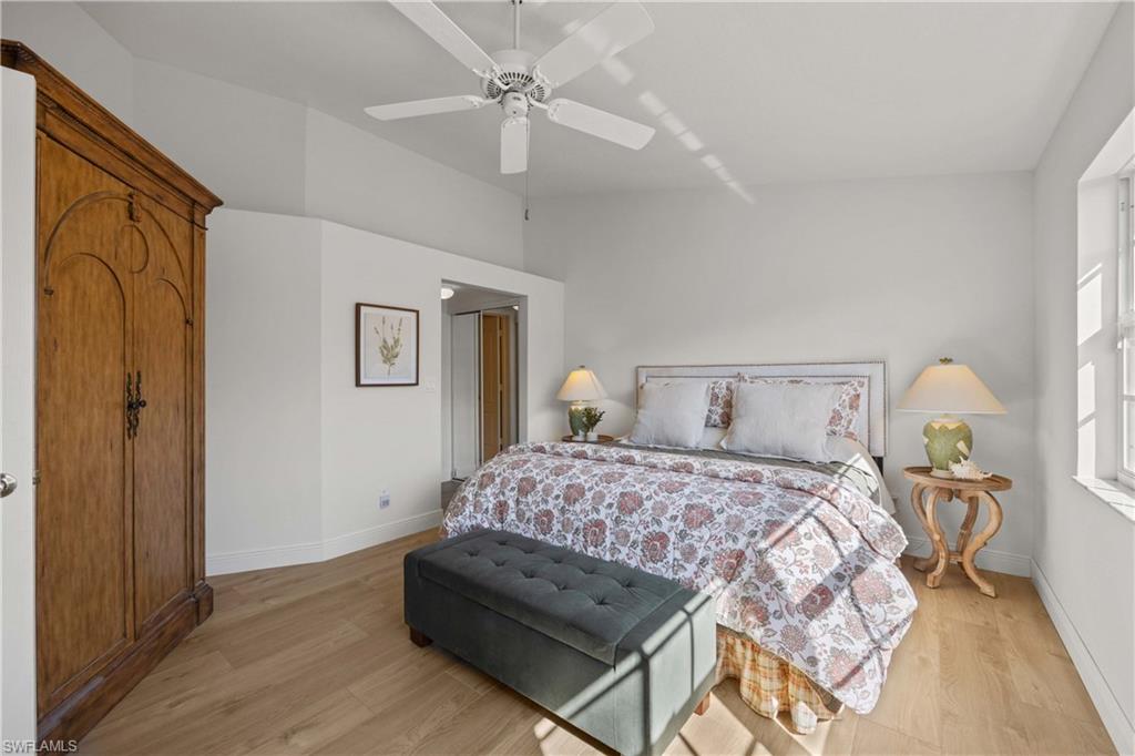 8415 Excalibur Circle, Unit B10 Naples, FL 34108 - Photo 14 of 26 a bedroom with a bed lamp and a chandelier