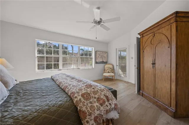 a living room with furniture a ceiling fan a lamp and a window