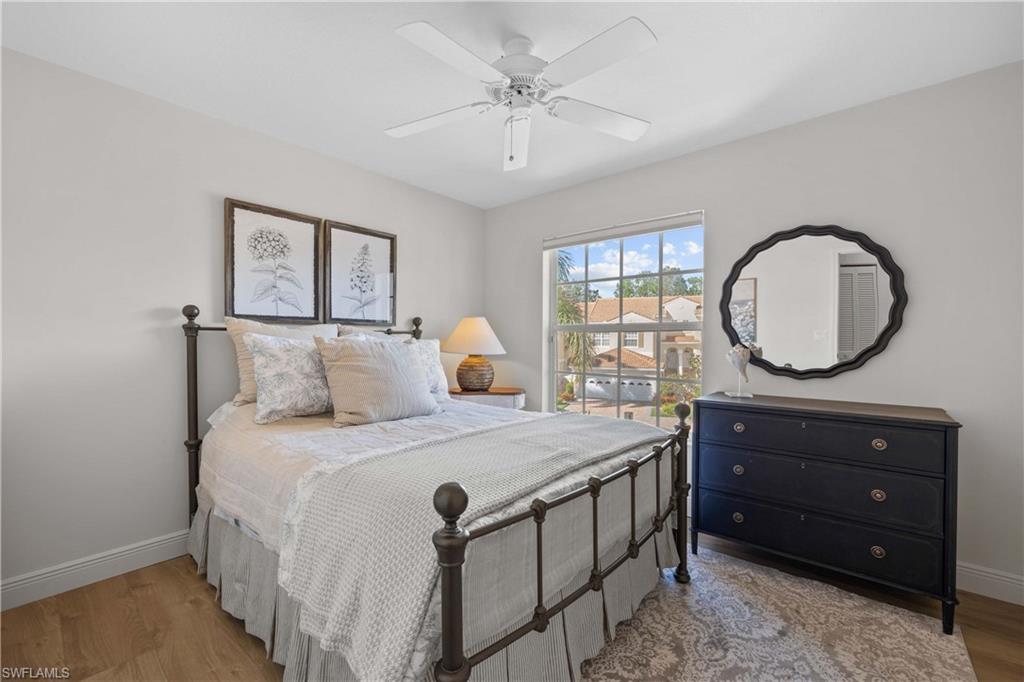 8415 Excalibur Circle, Unit B10 Naples, FL 34108 - Photo 18 of 26 a bedroom with a bed a mirror and a window
