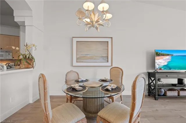 a living room with furniture a chandelier and a dining table